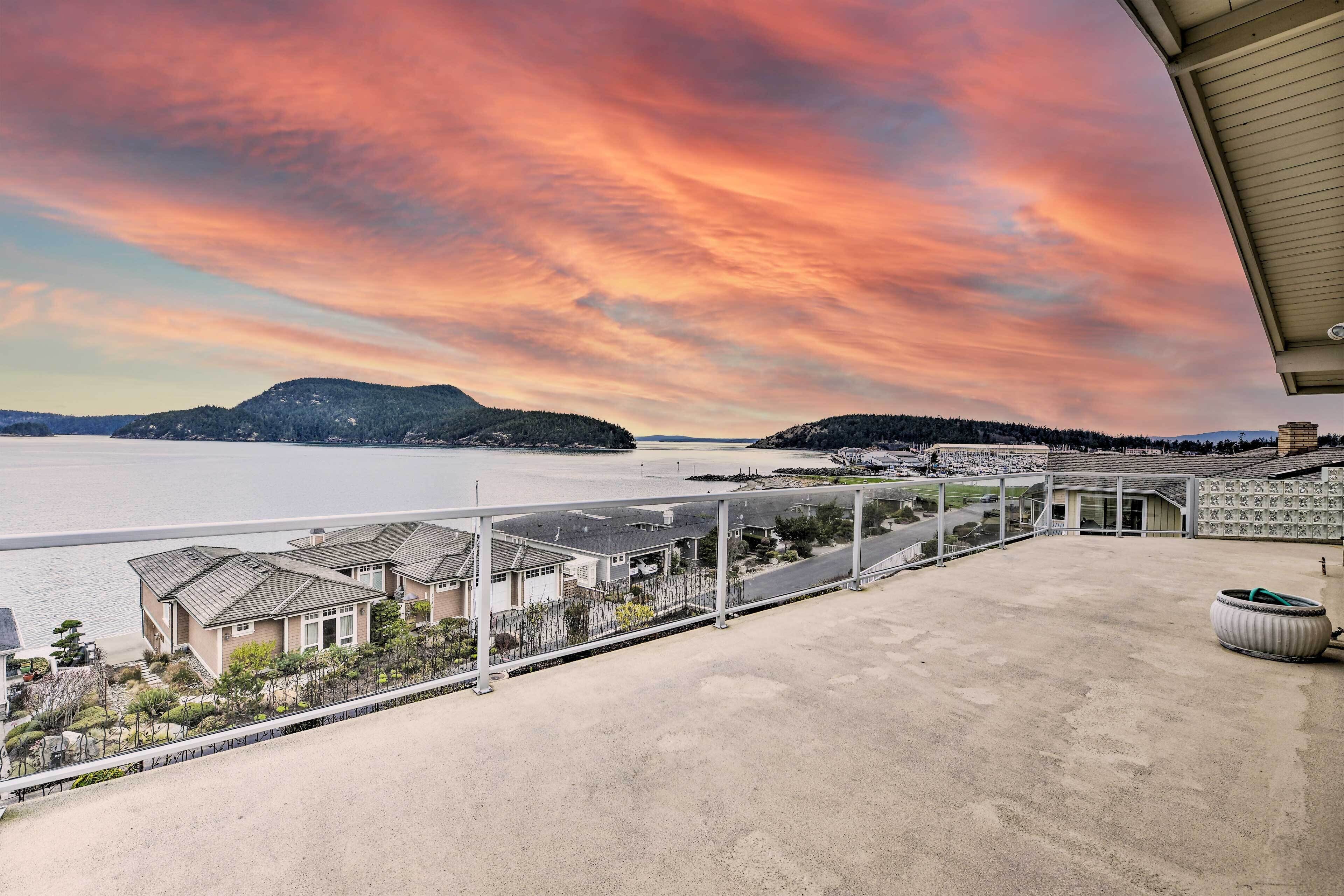 A coastal view with a clear sky, a marina, and residential buildings.