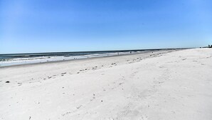 A wide sandy beach with a clear blue sky and calm sea. - Resort Condo w/ Beach Access in Indian Shores! (Indian Shores)