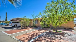 A parking area with a white van, a blue car, and a brick pathway leading to a building with a covered patio area. - El Paso Home < 1 Mi to Lone Star Golf Club! (El Paso)
