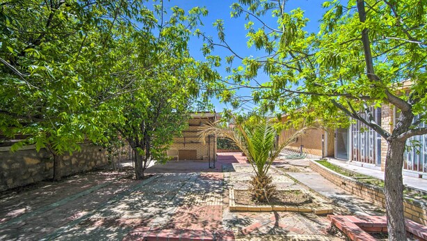 A courtyard with a paved walkway, trees, and a building with large windows. - El Paso Home < 1 Mi to Lone Star Golf Club! (El Paso)