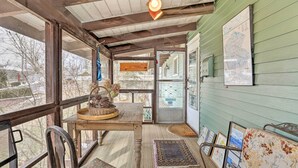 A cozy room with a wooden table, chairs, a patterned rug, and a map on the wall. - Waterfront White Lake Vacation Rental! (Kauneonga Lake)