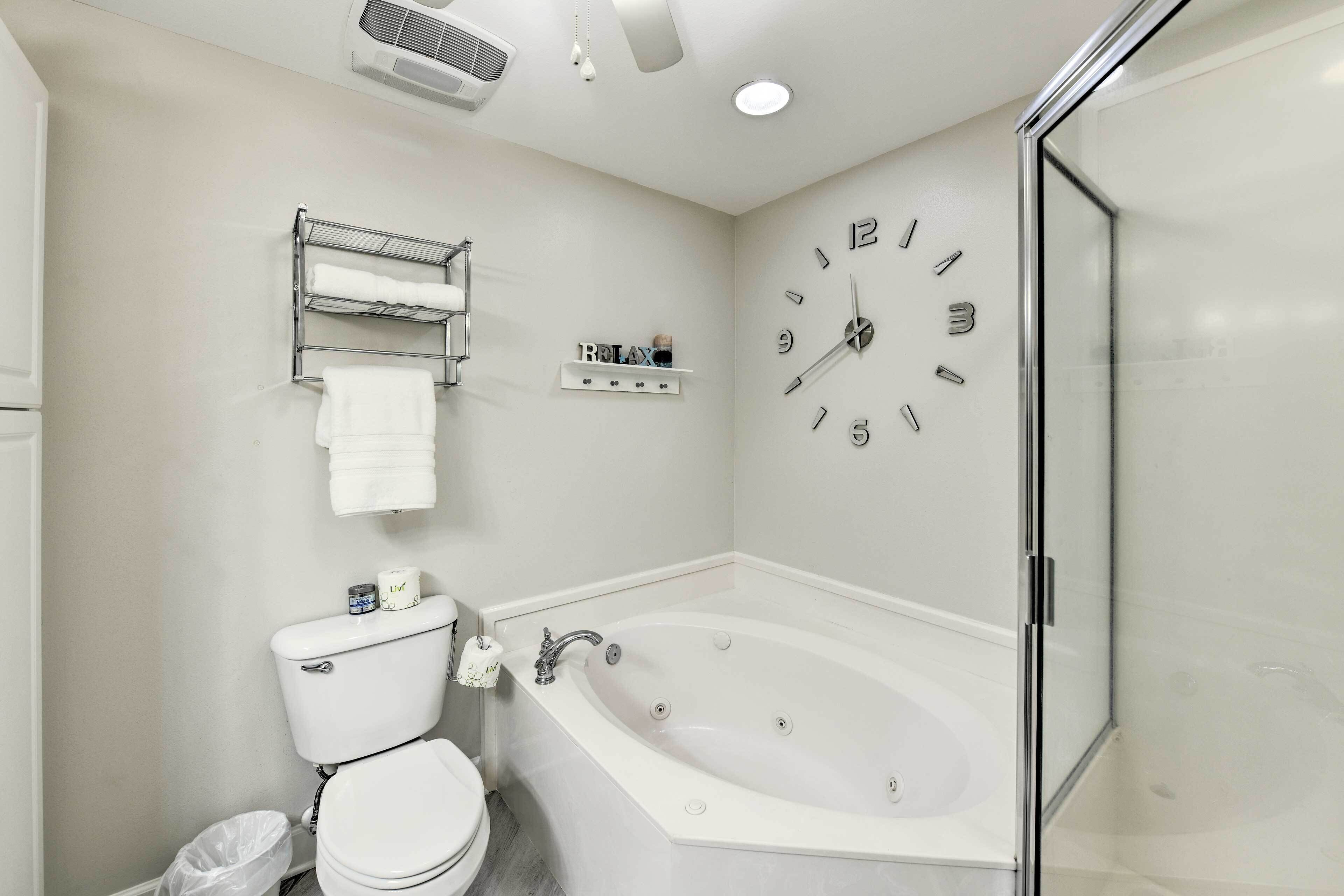 Een moderne badkamer met een vrijstaand bad, toilet en douchecabine.
