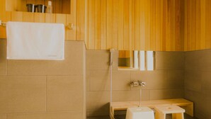 Un sauna de madera con un banco, una toalla y un espejo.