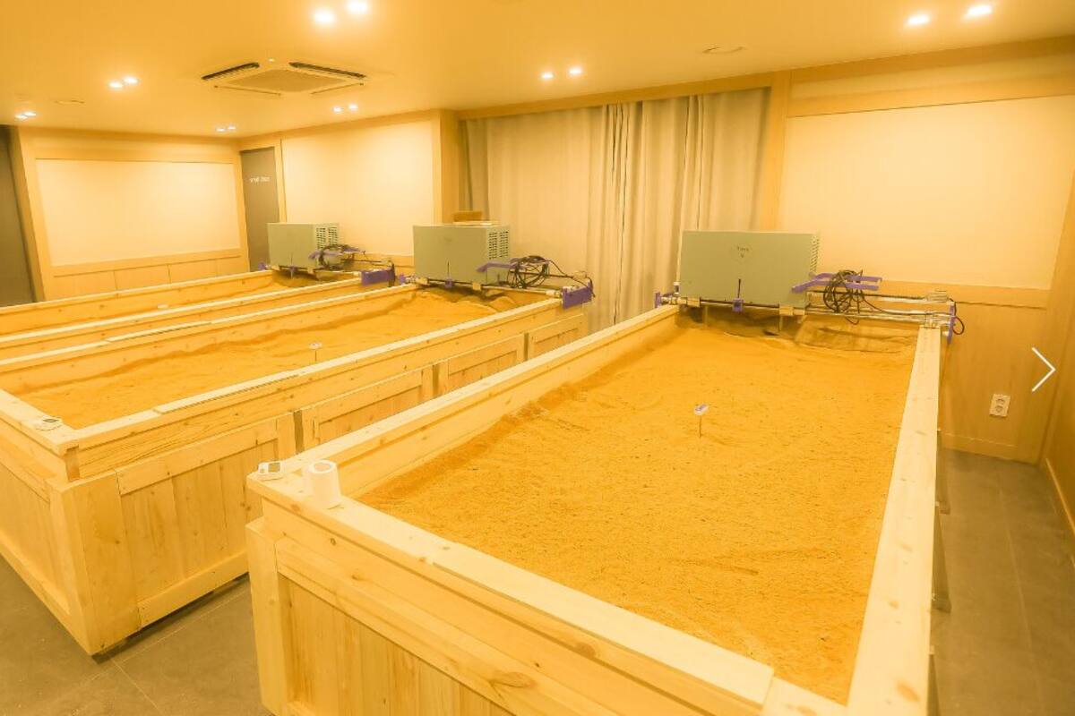Ein Zimmer mit mehreren Holzkleinbetten und Klimaanlagen.