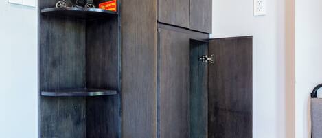 Una esquina con un mueble de madera oscura, una estantería con una bicicleta y una silla.