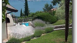 A view of a mountainous landscape with a lake, a pool, and a stone pathway. - Vacation home with private grounds and pool with panoramic views in Tremosine (Tremosine)