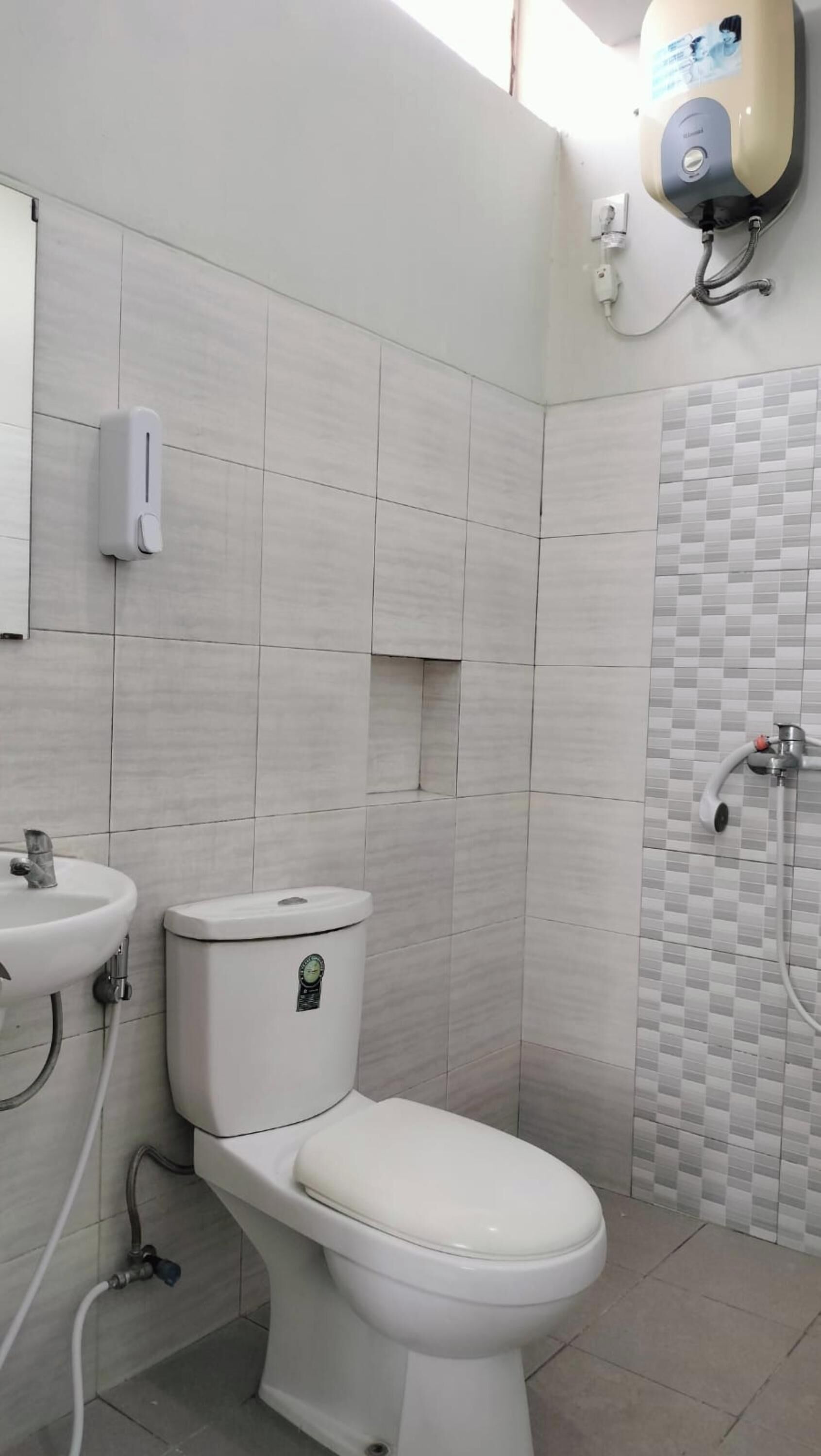A modern bathroom with a toilet, sink, and hand dryer.