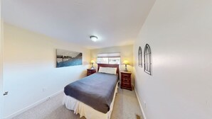 A bedroom with a bed, two bedside tables, a window, and a painting on the wall. - Rim Vistas - 5A8 (Moab)