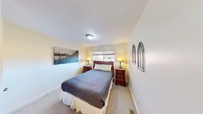 A bedroom with a bed, two bedside tables, a window, and a painting on the wall. - Rim Vistas - 5A8 (Moab)