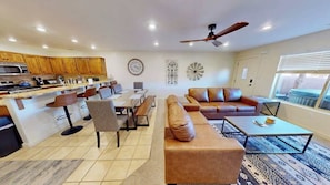 Una sala moderna con sofá, mesa de centro y comedor con sillas y mesa.