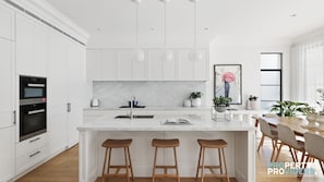 Enjoy cooking in this well-equipped kitchen with a large island, oven, and pendant lighting.