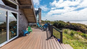 A wooden deck with outdoor furniture overlooking the ocean. - The Lookout - Beachfront, amazing views, spacious home (Cloverdale)