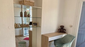 A room with a wooden desk, a green chair, a teddy bear, a glass shelf with decorative items, and two small stools with leaf patterns. - Villa with terrace 300 m from the sea (Antibes)