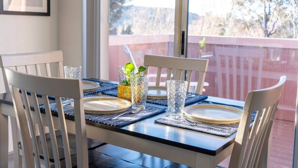 A dining table set with plates, glasses, and a centerpiece. - Charming & Artsy Half-House, Walk to Best of Sedona! Views, Yard & Firepit (Sedona)