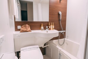 A bathroom with a white sink, wooden panel wall, and a shower. - R Hotel Honmachi (Osaka)