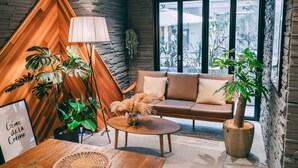 A modern interior with a wooden accent wall, a brown leather sofa, and a round coffee table. - R Hotel Honmachi (Osaka)