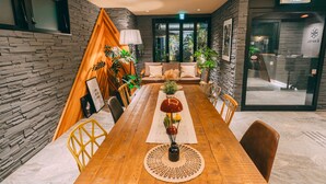 A modern dining area with a wooden table, yellow chairs, and a central decorative piece. - R Hotel Honmachi (Osaka)