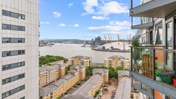 A high-rise building with a view of a river and construction cranes in the distance. - Lovely & Cosy 2 Beds London Skyline View (London)