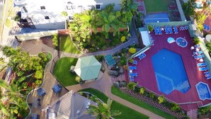 An aerial view of a resort with a swimming pool, sun loungers, and a covered seating area. - One Bed Room Ocean View With Surfers Holiday Accommodation - Aloha Apartments (Surfers Paradise)