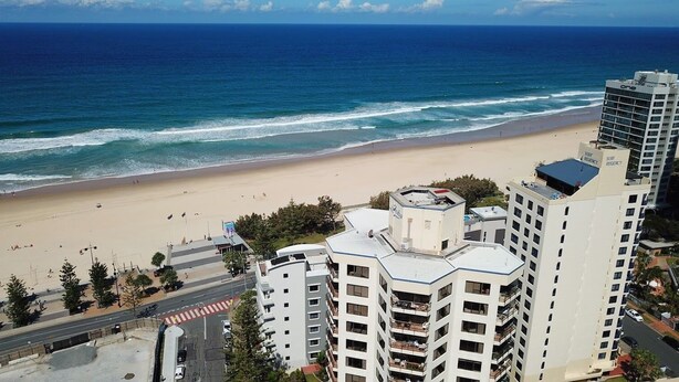 A beachfront hotel with multiple stories, a sandy beach, and the ocean in the background. - One Bed Room Ocean View With Surfers Holiday Accommodation - Aloha Apartments (Surfers Paradise)