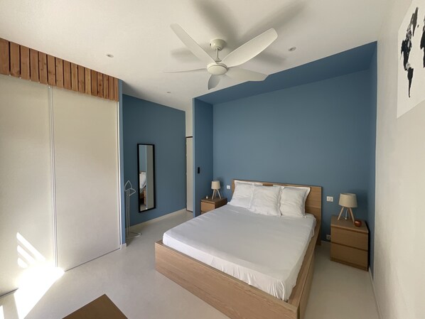 A bedroom with a bed, nightstands, a ceiling fan, and a large mirror. - Villa Contemporaine Avec Piscine . Le 210 (Saint Alban Auriolles)