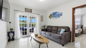 A modern living room with a grey sofa, a wooden coffee table, and a 'Welcome' sign. - Miami Tropical Retreat: Private Pool & Patio (Miami)