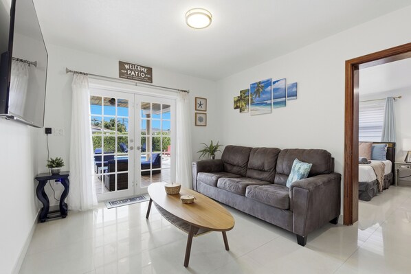 A modern living room with a grey sofa, a wooden coffee table, and a 'Welcome' sign.