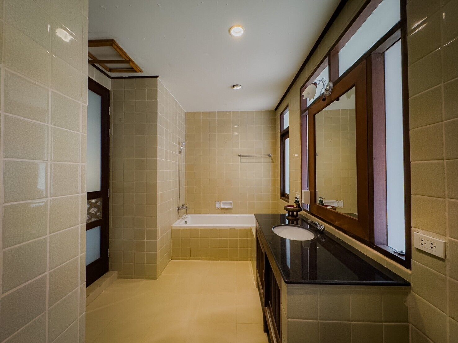 Une salle de bain moderne avec une baignoire, un lavabo et un grand miroir.