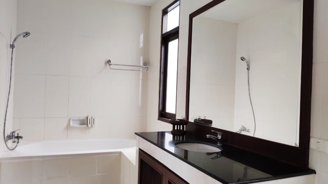Un baño moderno con una bañera, un espejo grande y una ducha.