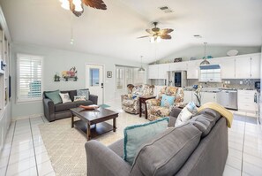 A spacious living room with a sofa, coffee table, and patterned rug.