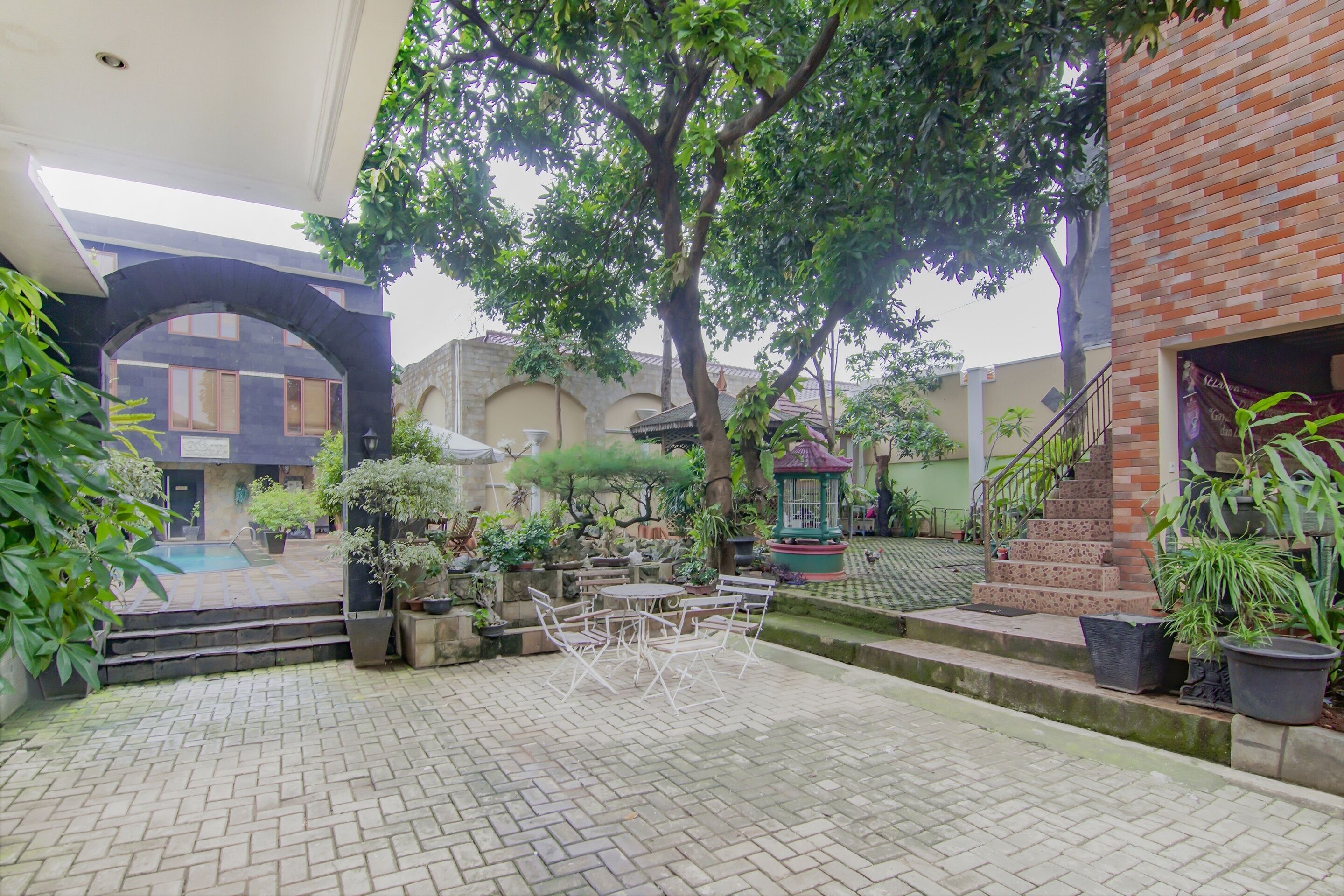 A courtyard with a brick wall, a staircase, and a pool area.
