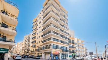 Un immeuble à plusieurs étages doté de balcons, un atelier de carrosserie et un restaurant situés au rez-de-chaussée.