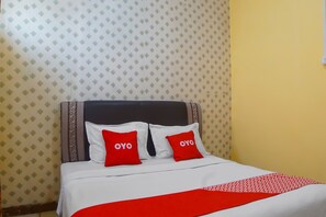 Un lit avec une literie blanche et des oreillers rouges, une couvre-lit rouge et blanche, et un papier peint à motifs.