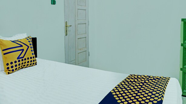 Ein Zimmer mit einem Bett, einer weißen Tür und einem grünen Schrank.