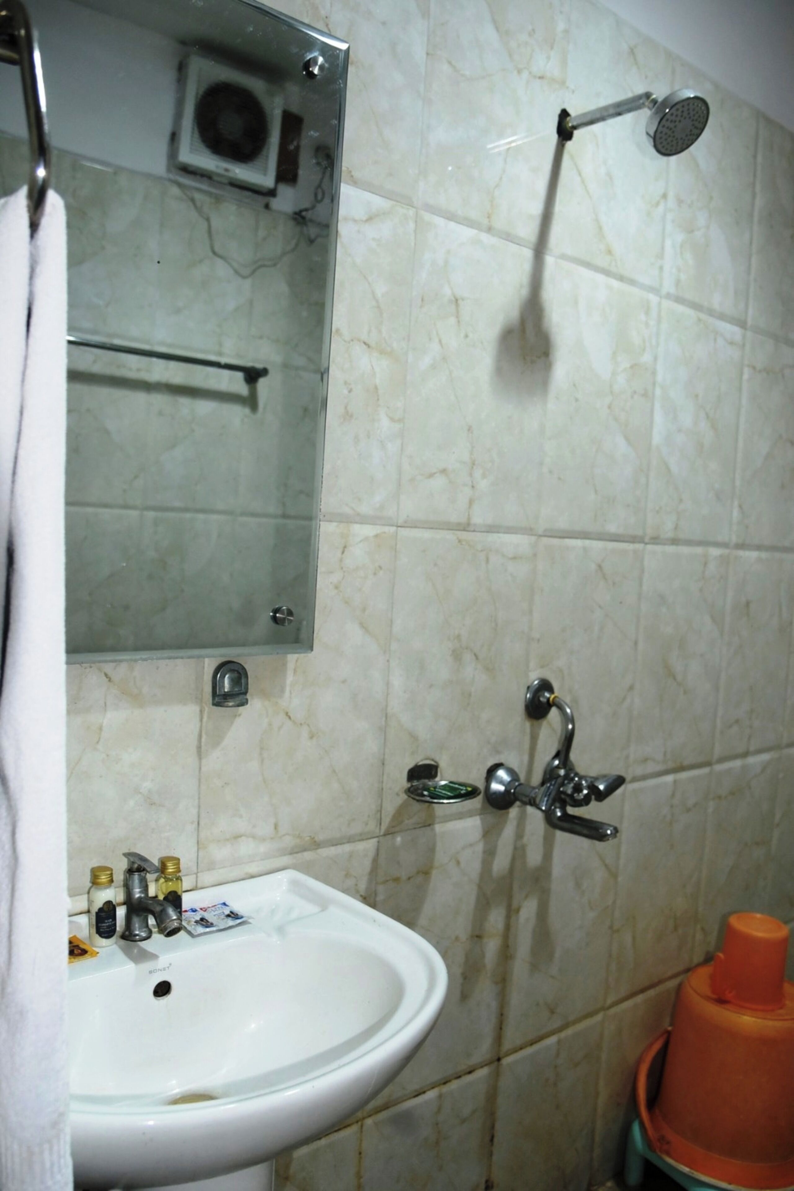 A bathroom with a white sink, mirror, and shower.