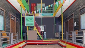 Een meerlaags gebouw met een trap, vlaggen in verschillende kleuren en een bord waarop een prijs van 2.000 staat.