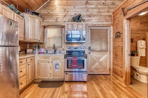Chalet rustique, 1 très grand lit, baignoire à remous, vue sur la montagne | Cuisine privée | Réfrigérateur, four à micro-ondes, un four, surface de cuisson