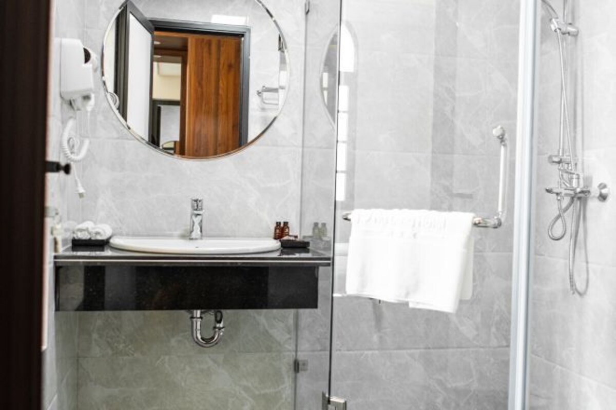 Deep-soaking bathtub, rainfall showerhead, designer toiletries