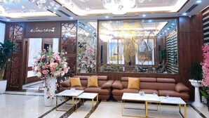 A luxurious lobby with a chandelier, seating area, and a restaurant sign. - JADE HA LONG HOTEL (Bai Chay)