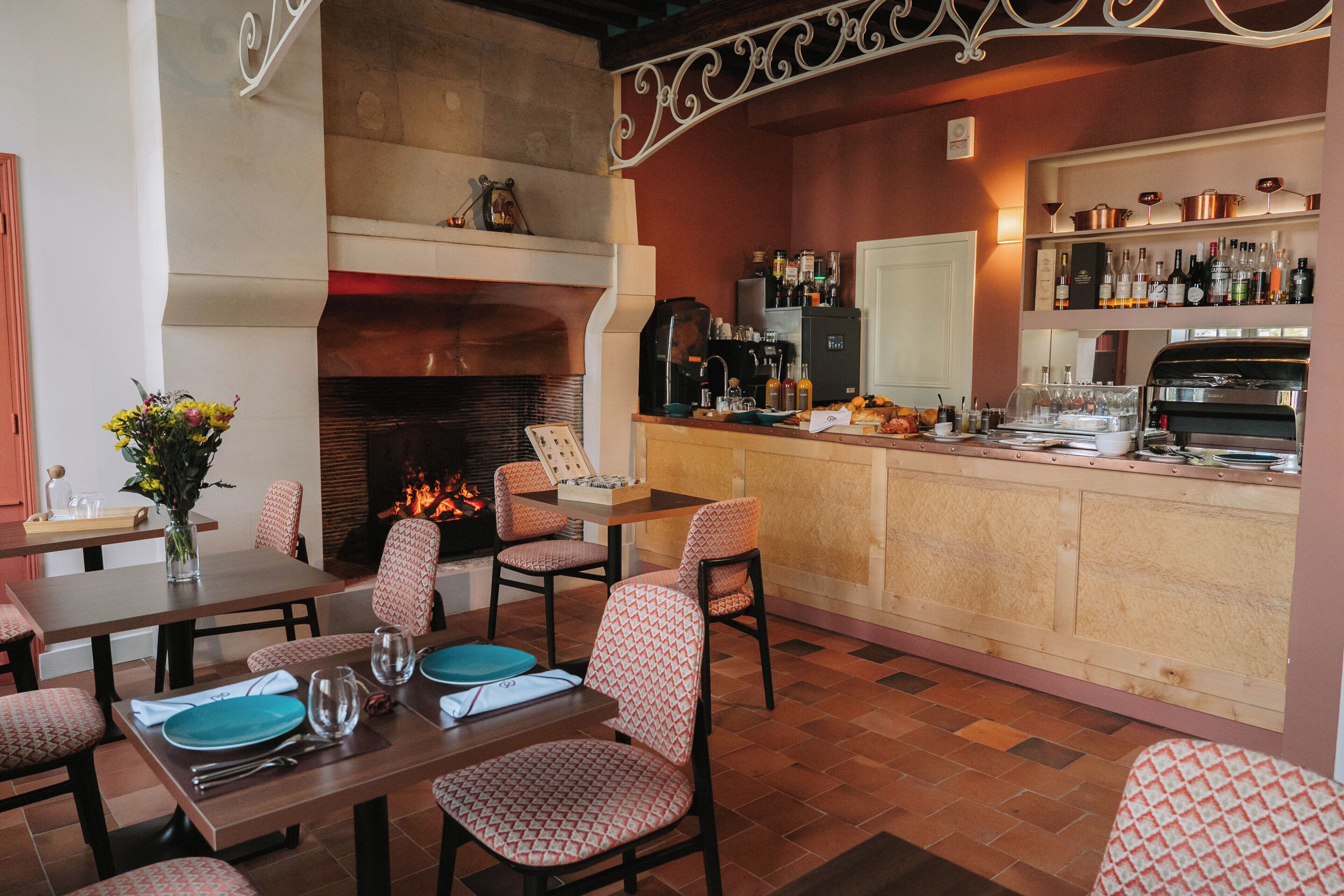 A restaurant with a bar area, seating, a fireplace, and a wine display.