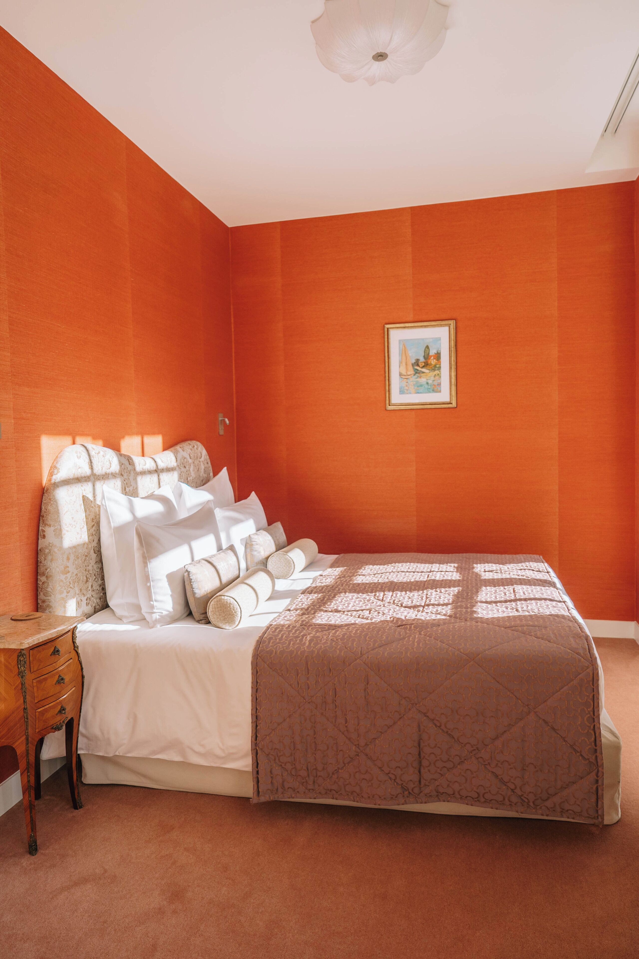 Un dormitorio con una cama grande, una mesita de noche y un cuadro enmarcado en la pared.
