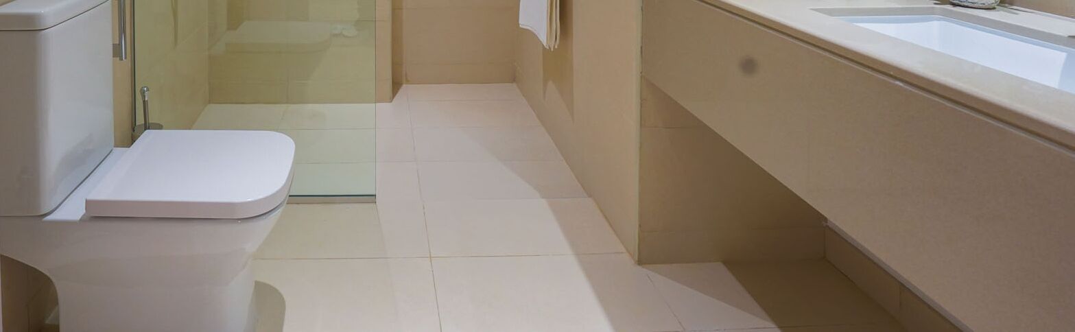 A modern bathroom with a toilet, a glass shower enclosure, and a sink.