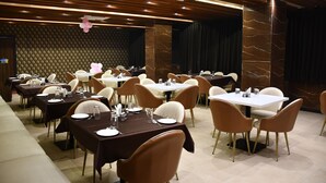 Un restaurante con varias mesas y sillas, dispuesto en un espacio amplio.