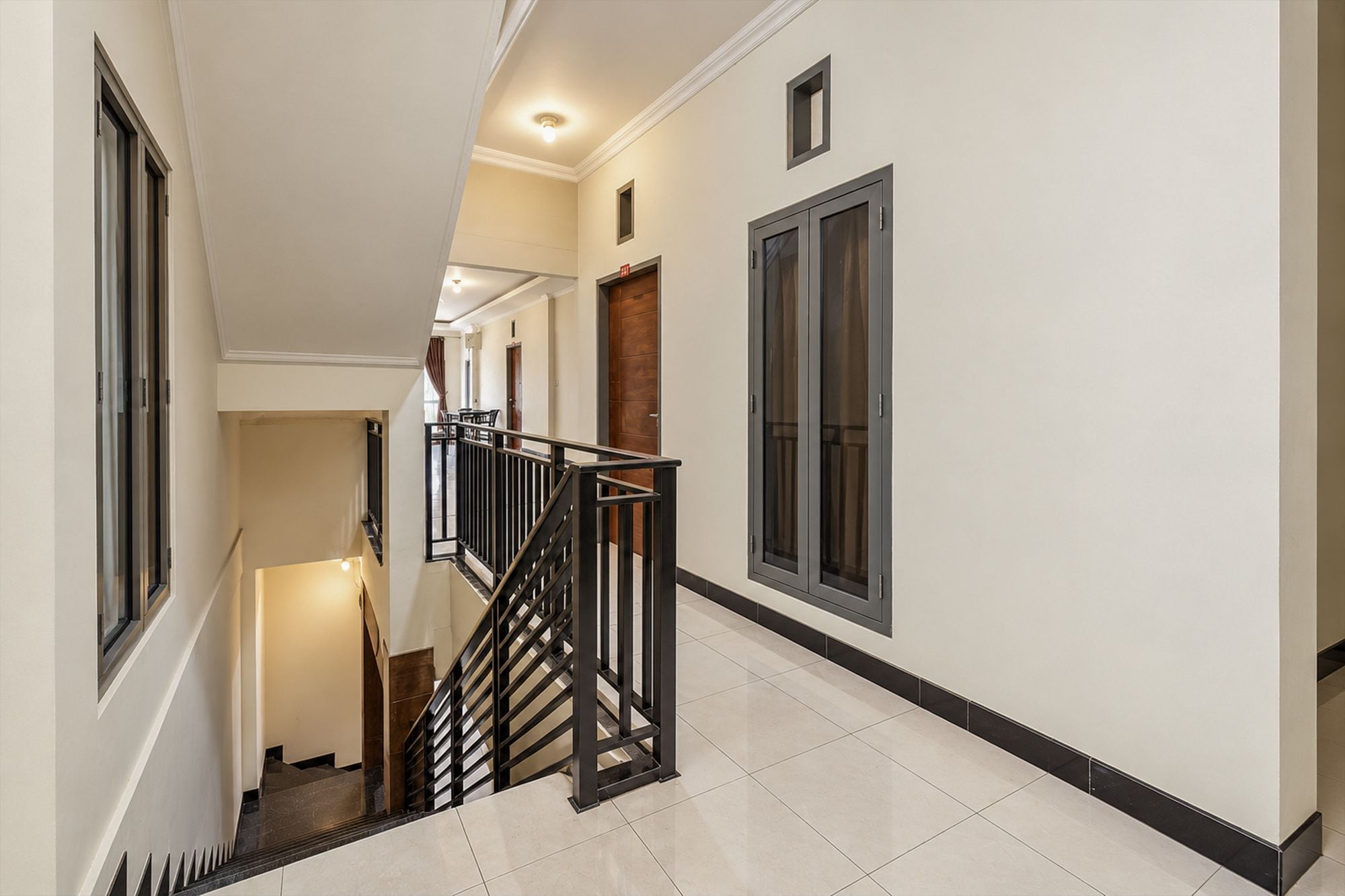 Interior com vários níveis, incluindo uma escada, uma porta e uma janela.