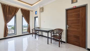 A room with a dining table and chairs, a wooden door, and a view through a window.