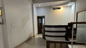 Zona de recepción con mostrador, escalera y piso de baldosas.
