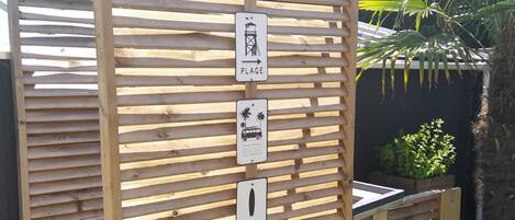 A wooden fence with directional signs for 'Plage' and 'Surf'.