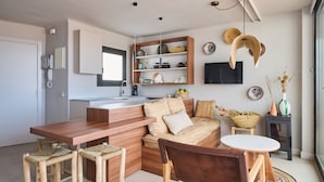 Une cuisine moderne avec des meubles en bois, un îlot central intégré et un coin repas avec des tabourets.