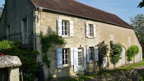 A stone house with white shutters, a balcony, and a small garden area. - Authentic country house in Tannay with garden (Tannay)