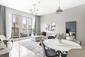 A modern living room with a large window, a dining table, and a sofa. - Silkhaus Standpoint, Downtown Dubai (Dubai)